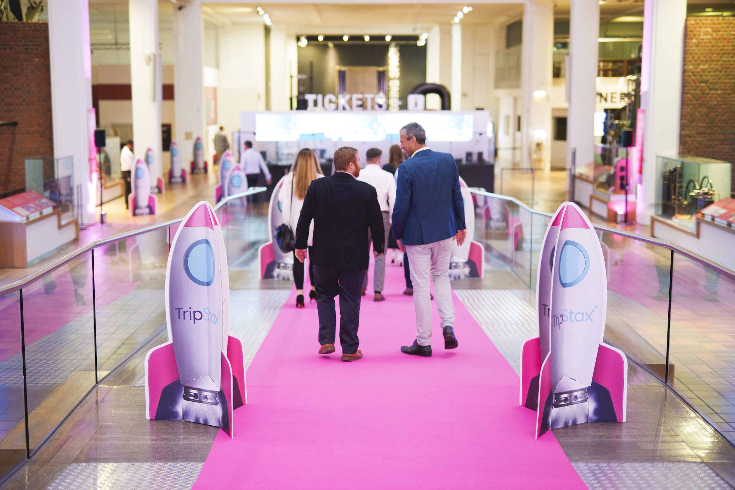 Energy Hall entrance with pink carpet and rocket displays for tech event excitement.