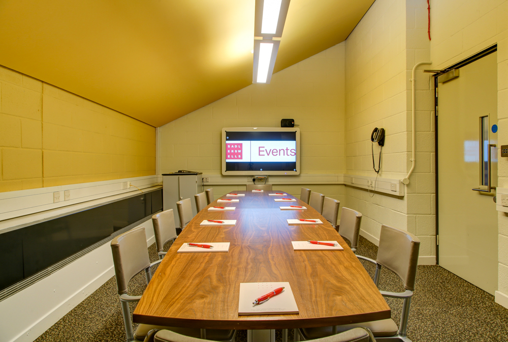 Teneisha Bonner in a professional meeting room with a large screen for events and training.