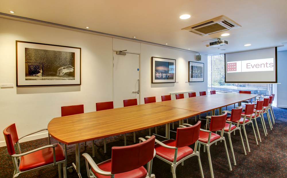 Pina Bausch Room at Sadler's Wells: modern meeting space with wooden table and red chairs.