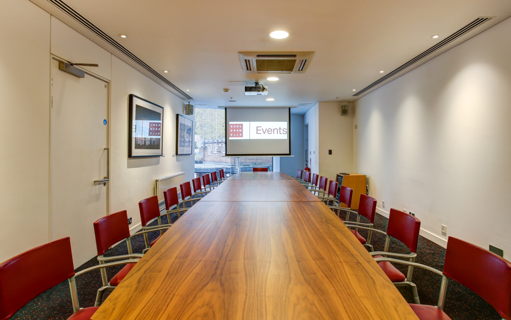 Pina Bausch Room at Sadler's Wells: modern meeting space with wooden table and red chairs.