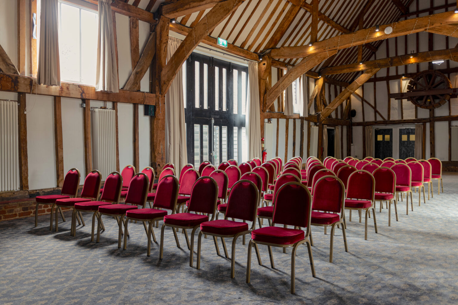 Manor Barn event space with red chairs, ideal for workshops and seminars.