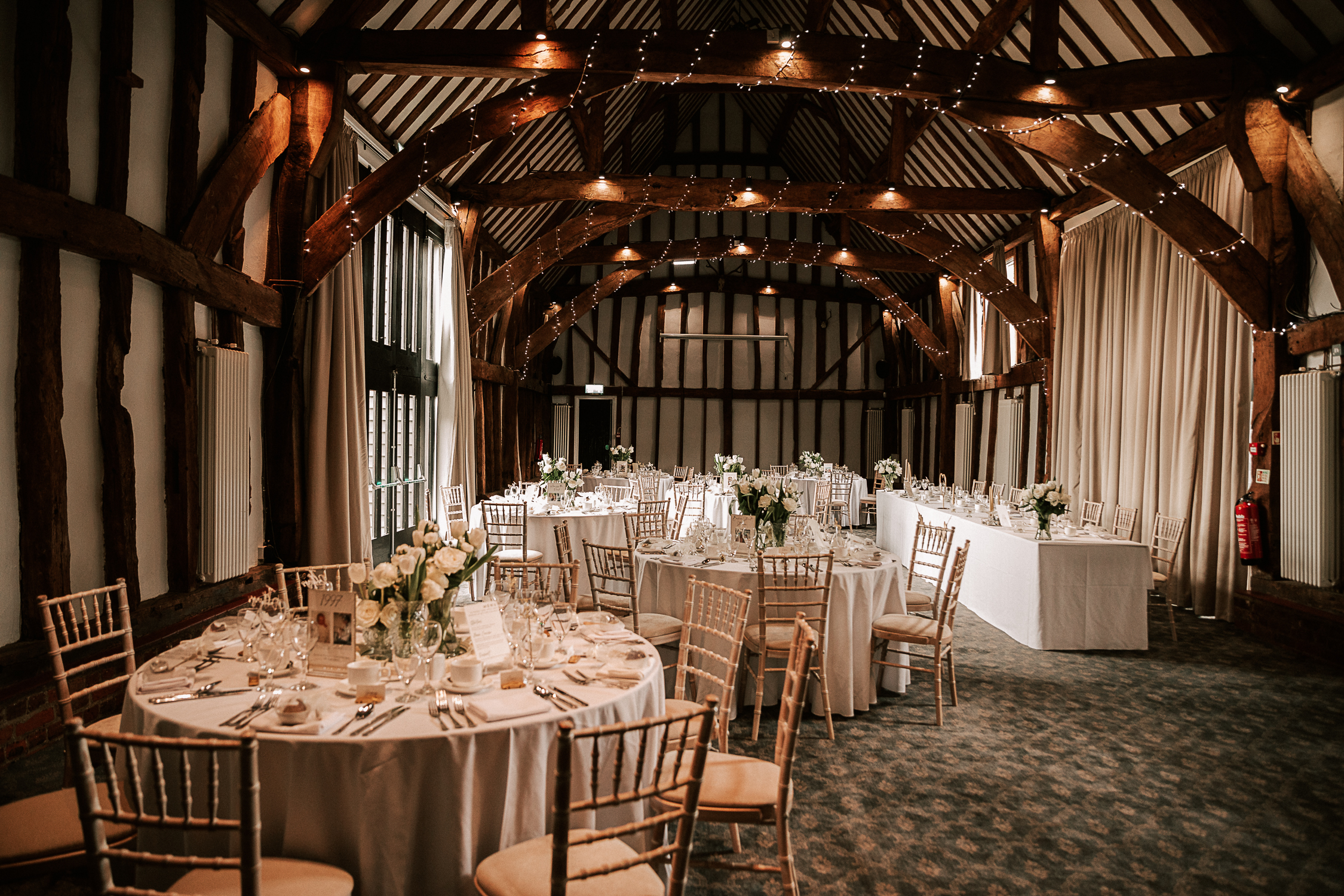 Manor Barn event space with elegant tables, ideal for weddings and gatherings.