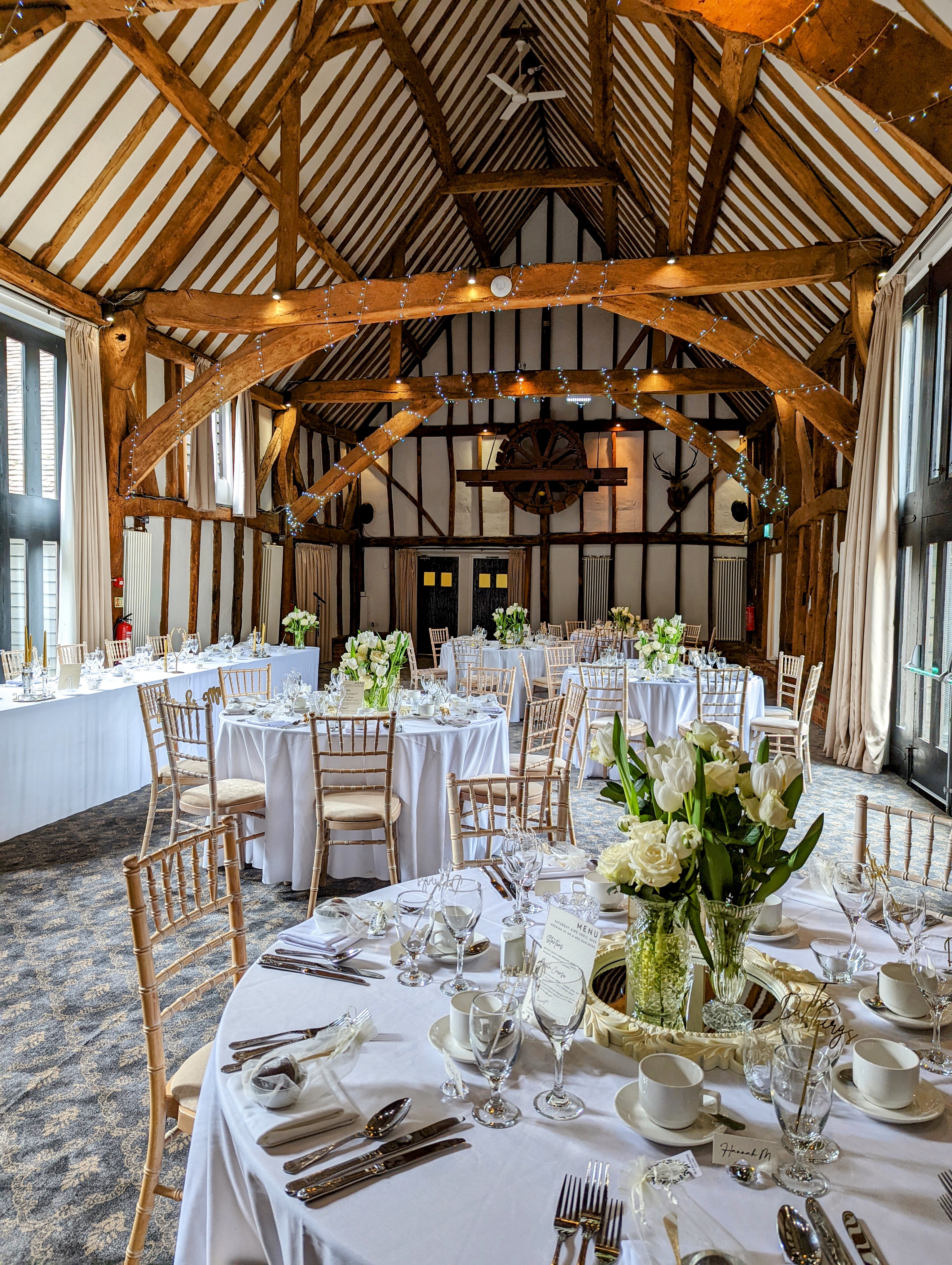 Manor Barn at Knebworth House: rustic beams, elegant wedding venue with floral decor.