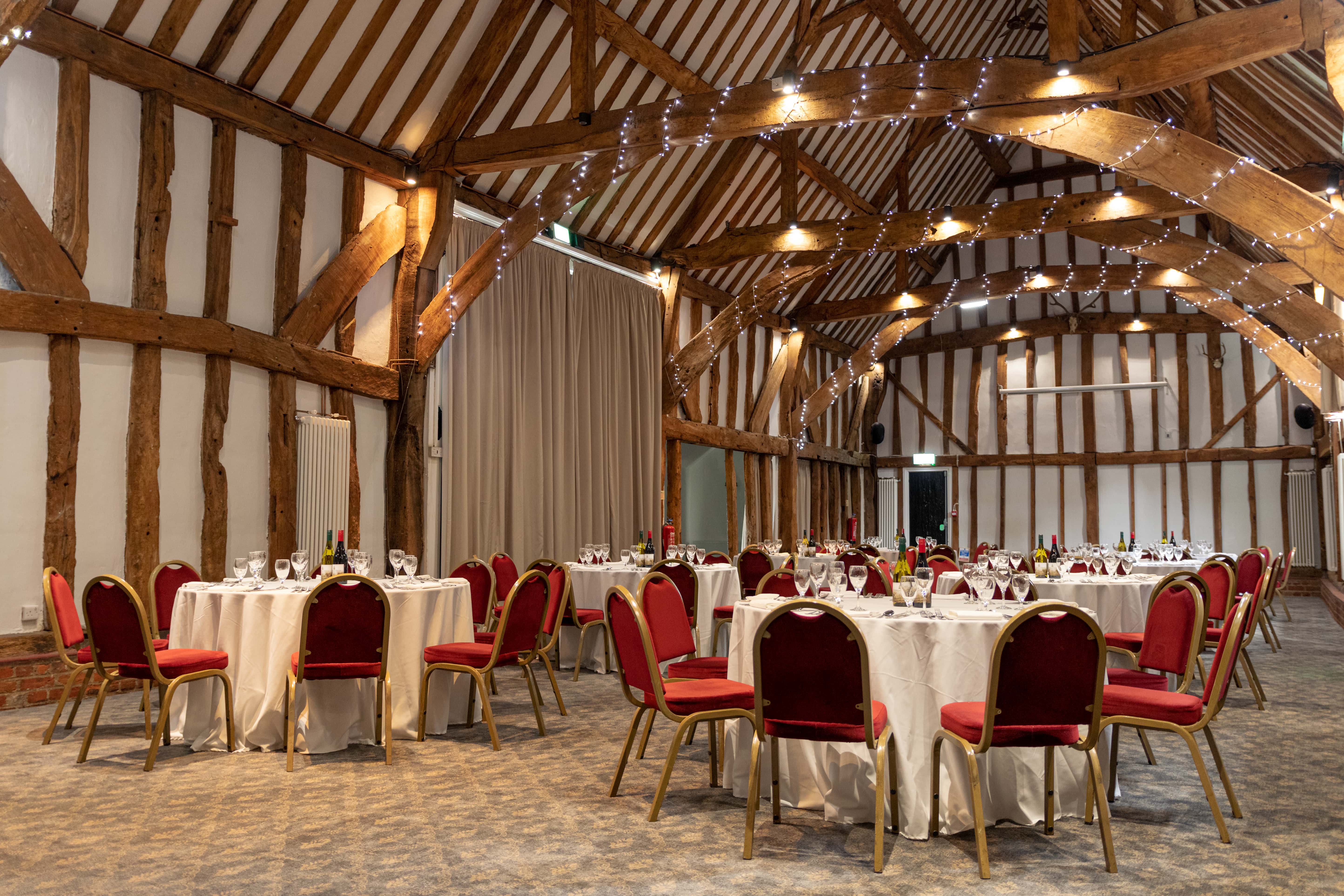 Manor Barn event space with round tables, ideal for weddings and corporate gatherings.