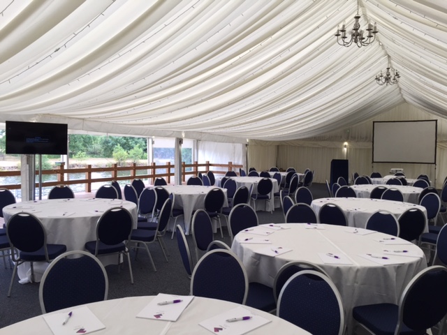 Elegant event space with round tables, ideal for corporate meetings or banquets.