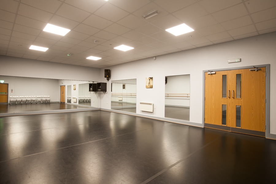 Versatile dance studio with polished floors, ideal for workshops and classes.