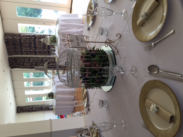 Elegant Britannia Suite table with floral birdcage centerpiece for weddings or events.