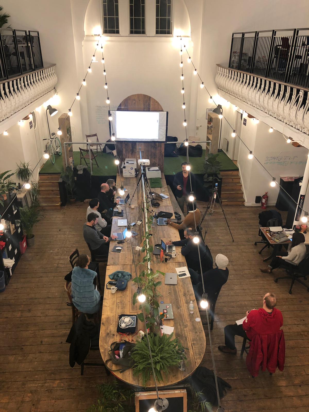 Collaborative meeting space at Launch22 King's Cross with wooden table for workshops.