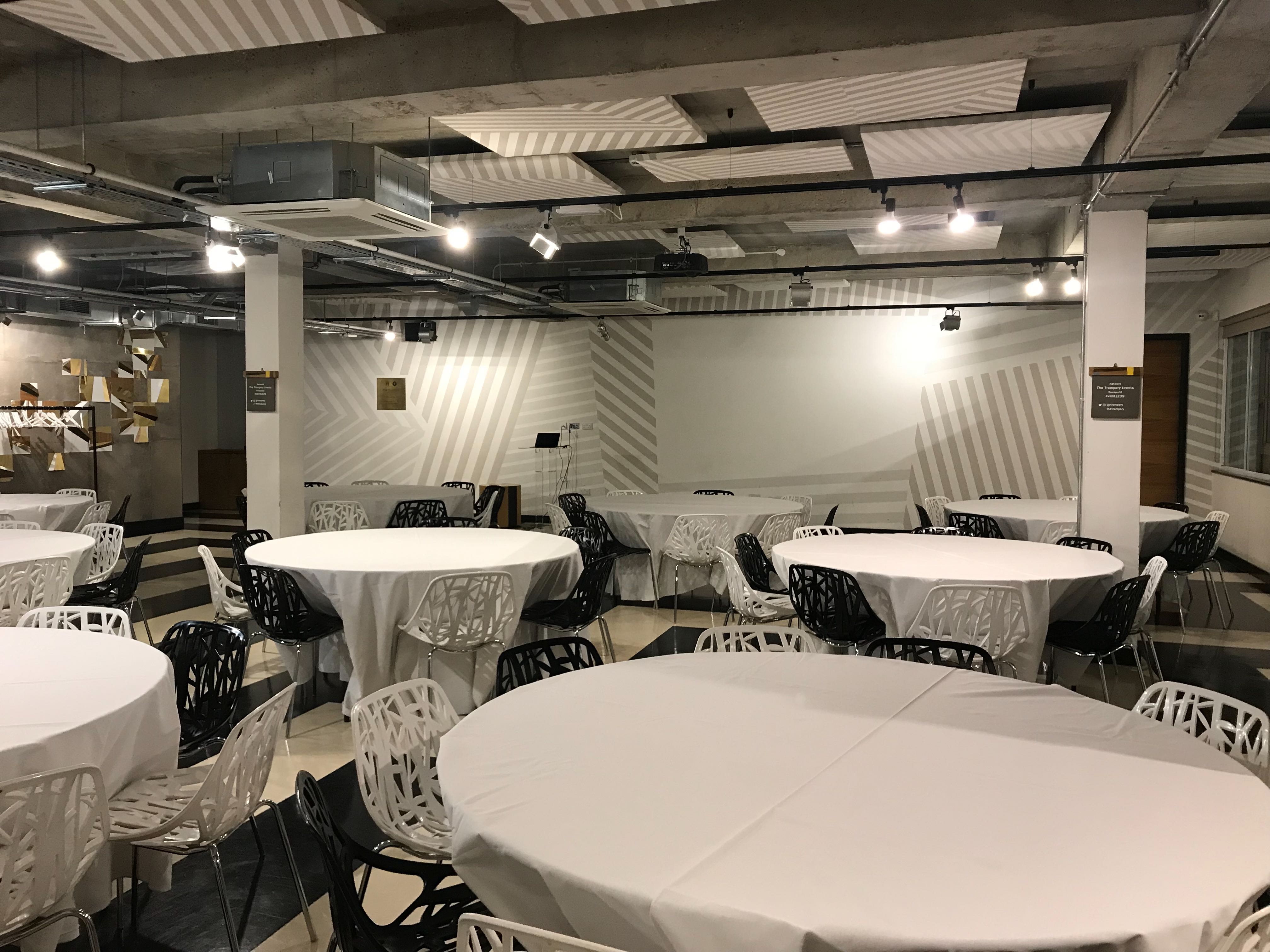 Versatile event space with round tables, ideal for meetings and social gatherings.