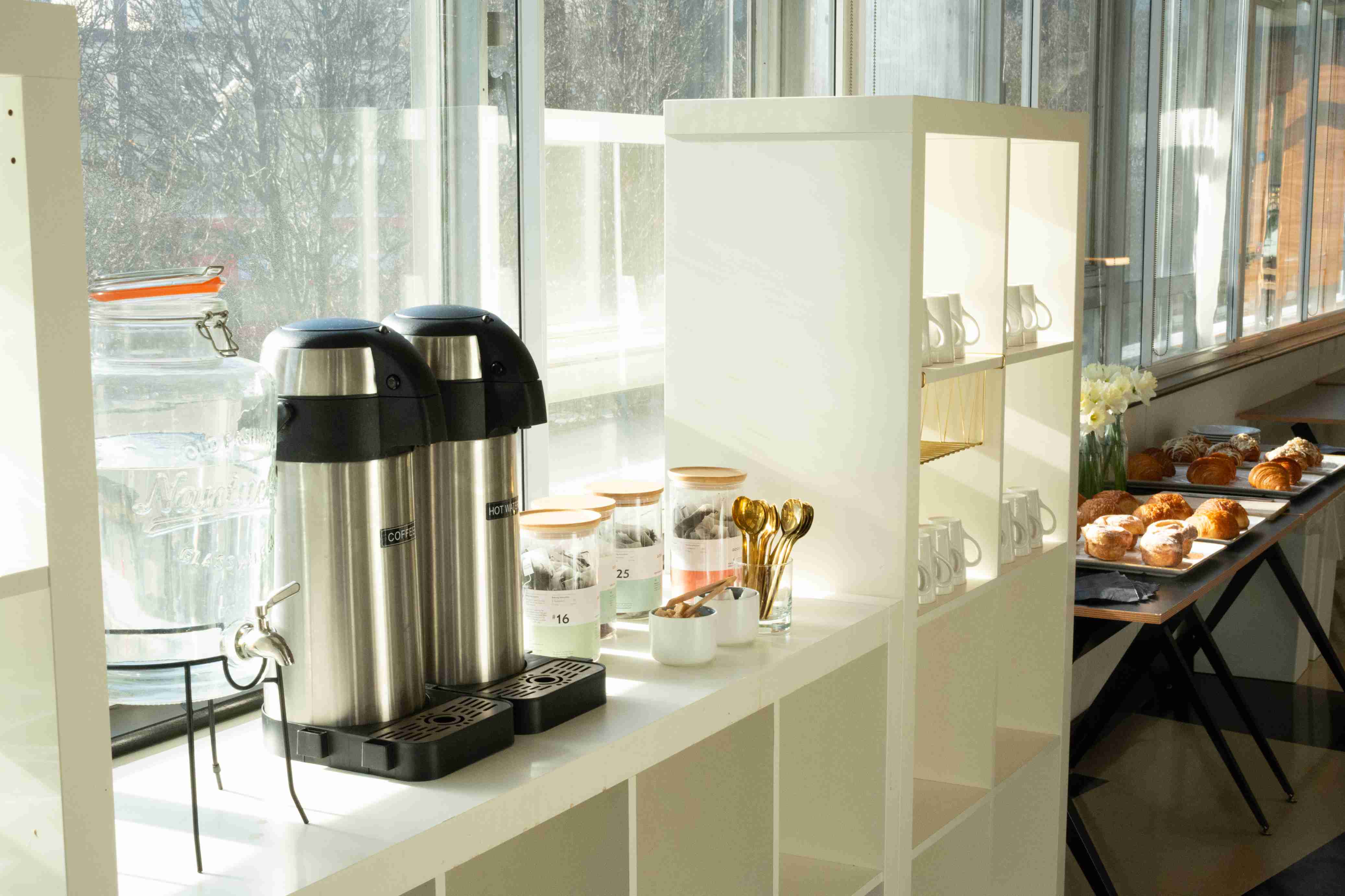 Refreshment station with coffee dispensers and pastries in The Trampery Old Street ballroom.
