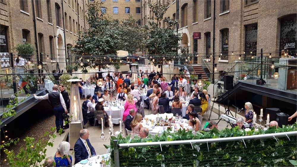 Vibrant event space with greenery and string lights for networking or celebrations.