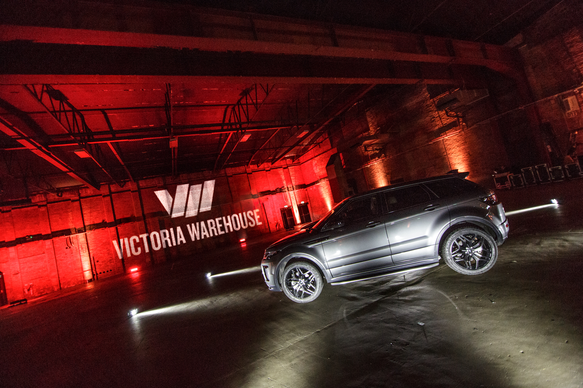 Event setup at Victoria Warehouse with dramatic lighting and sleek vehicle for product launch.