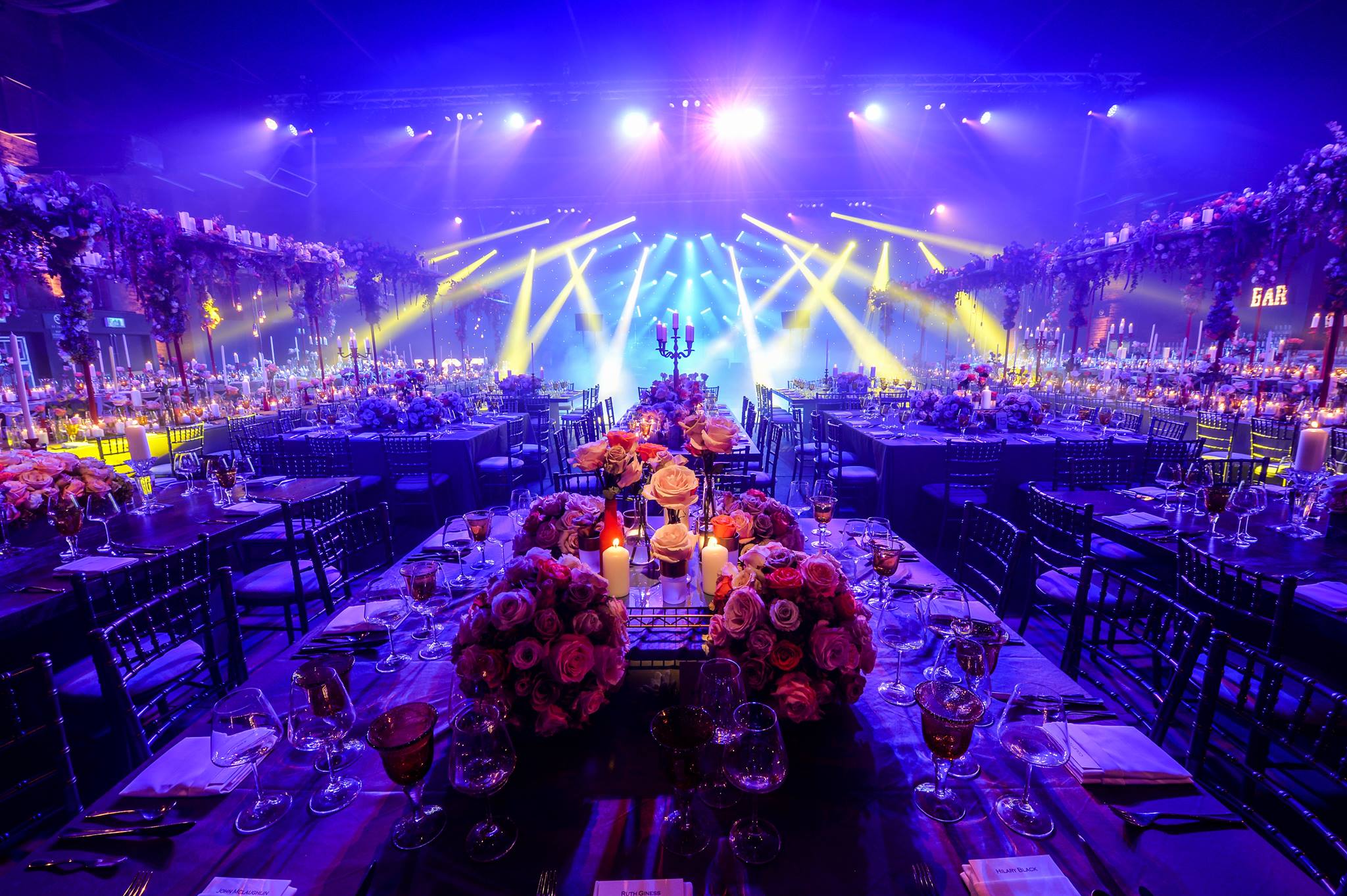 Elegant event setup at The Cotton Sheds, featuring floral centerpieces and ambient lighting.