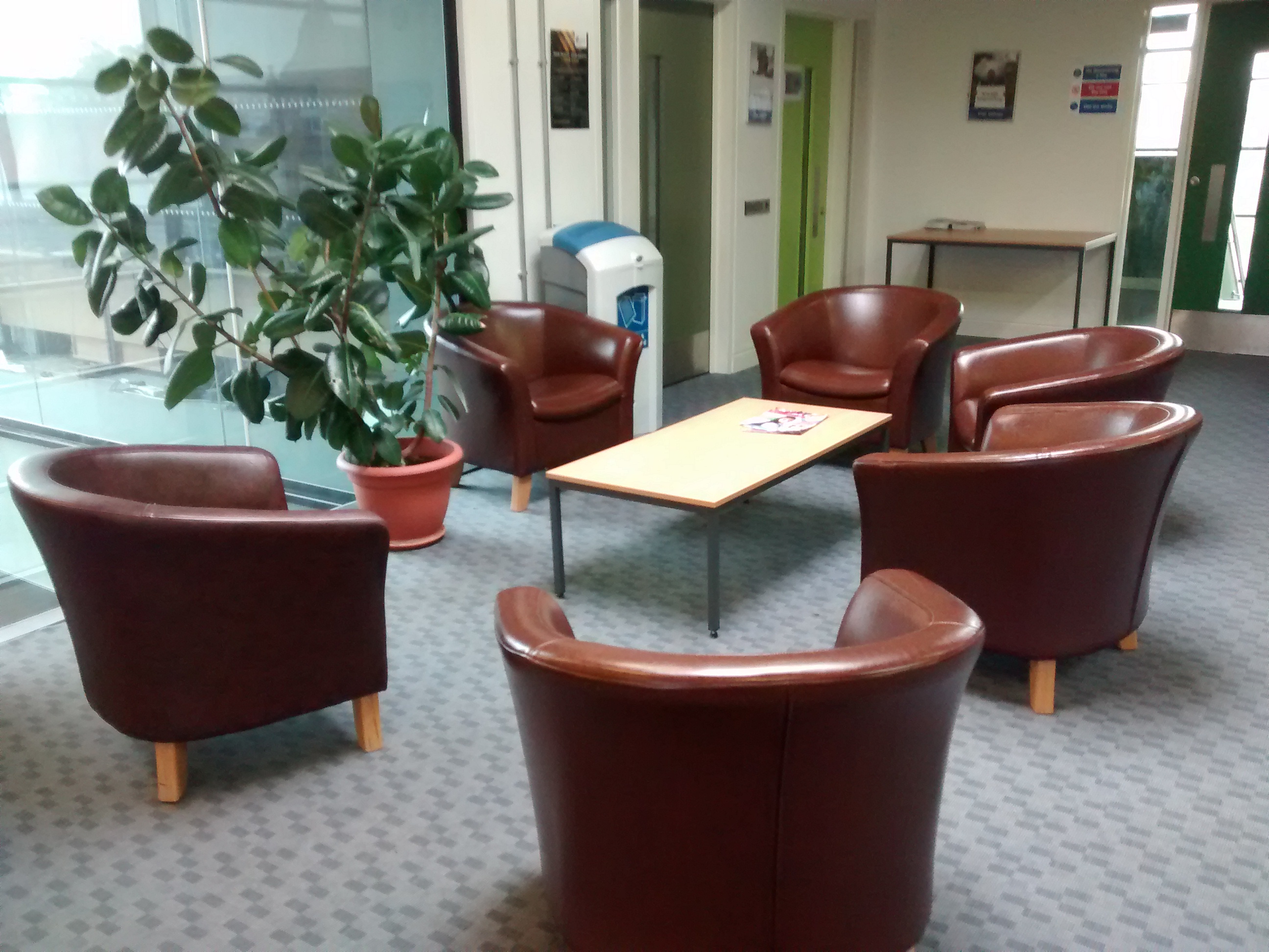 Cozy training room with brown leather chairs for informal meetings and networking events.