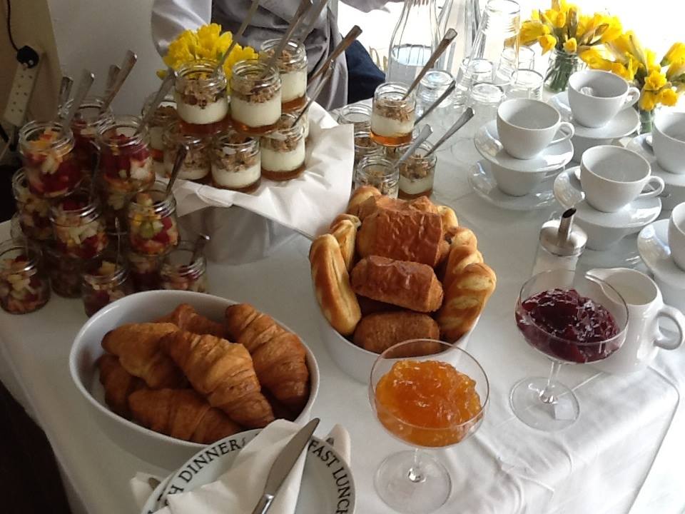 Elegant breakfast spread with pastries and parfaits for morning meetings or events.