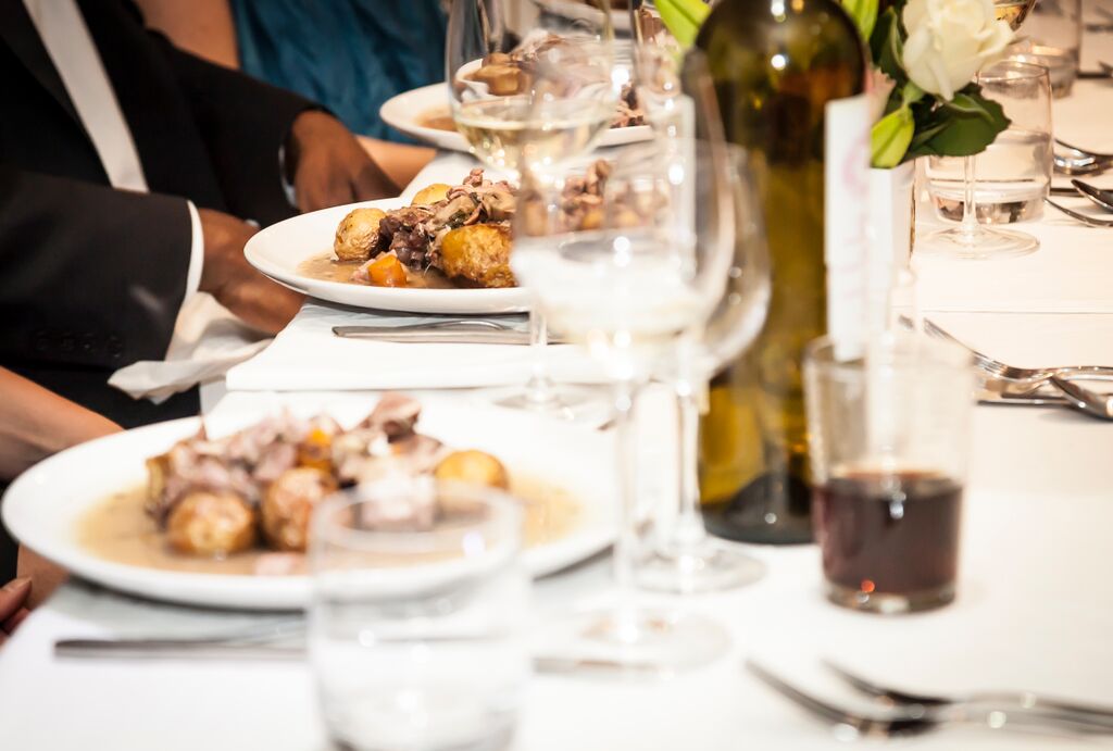 Elegant dining table setup with floral arrangements for a formal gala event.
