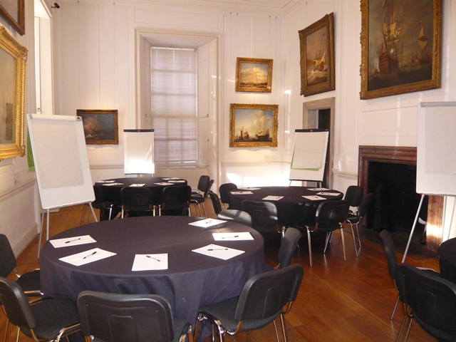 Elegant meeting space in The Queen's House with round tables for workshops and discussions.