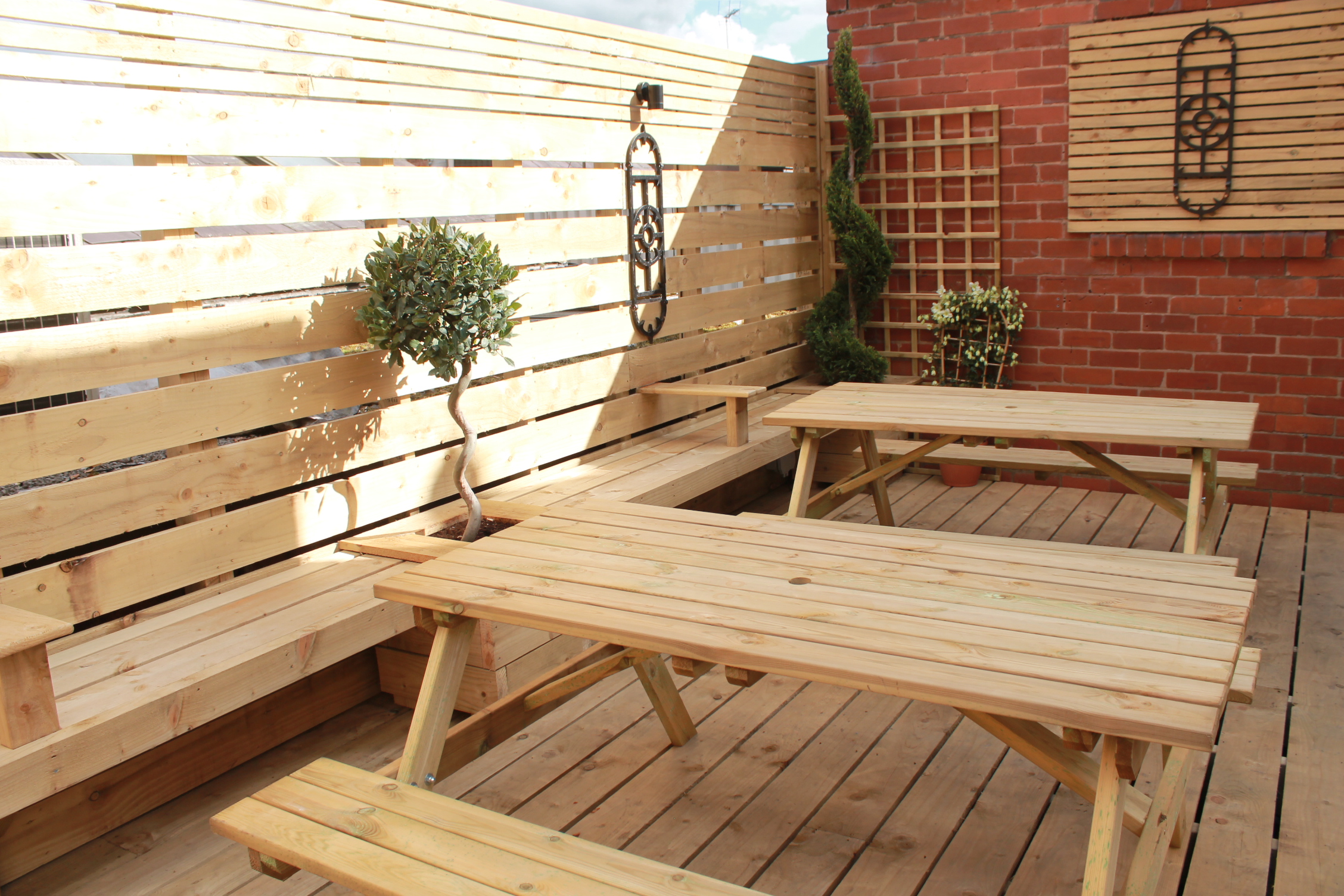 Roof terrace with wooden tables, greenery for casual meetings and networking events.
