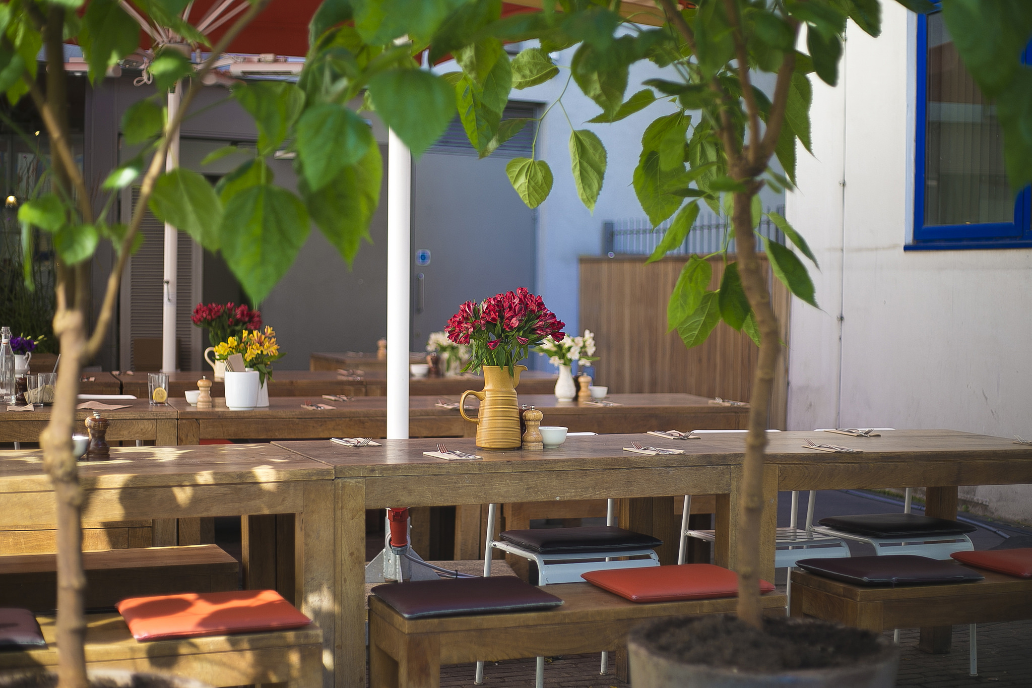 Charming outdoor dining at The Table Cafe with rustic tables and floral decor.