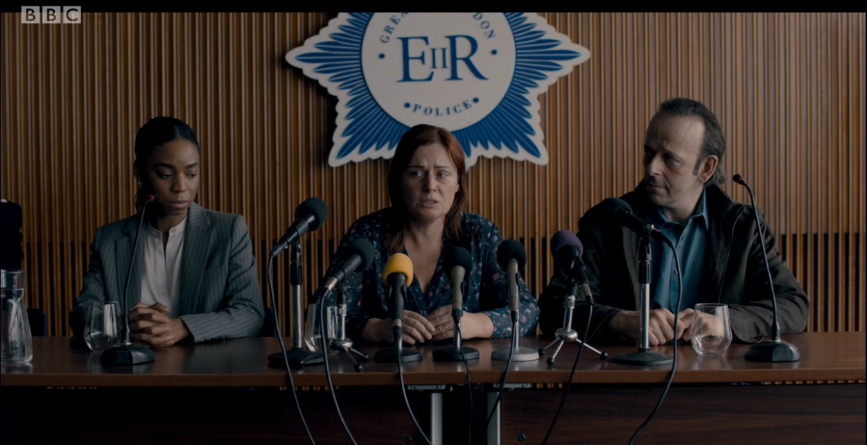 Council Chamber press conference with cluttered dais, ideal for corporate event venue hire.