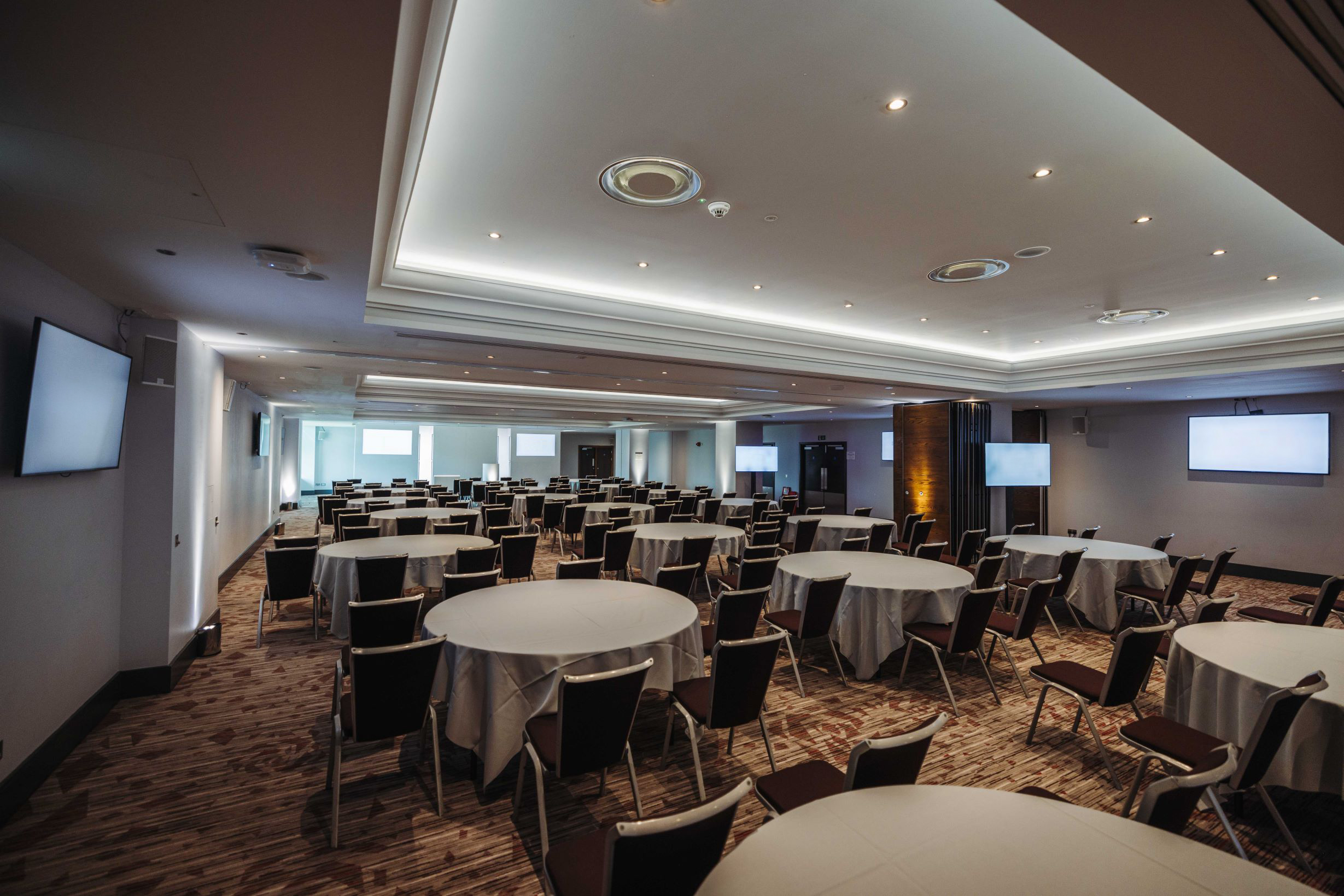 Elgar Suite at Allianz Stadium: modern event space with round tables for meetings and presentations.