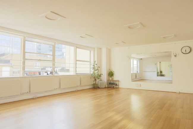 Bright London rehearsal space with large windows, ideal for workshops and yoga sessions.
