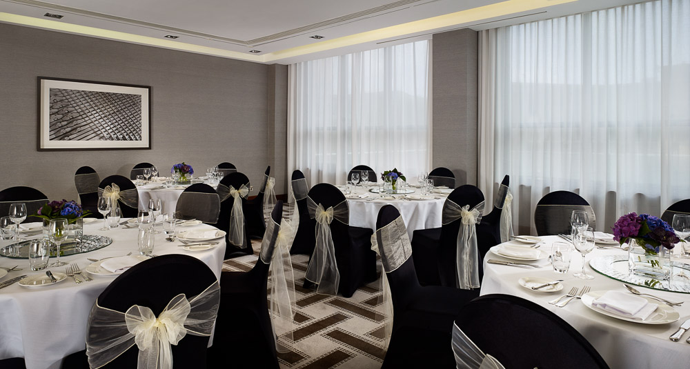 Elegant event space at Hyatt Regency Birmingham with white tables and floral centerpieces.