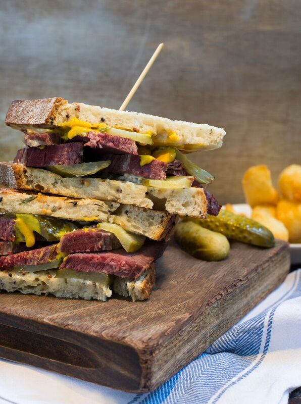 Towering sandwich with corned beef and cheese at Balfour St Bart's event venue.