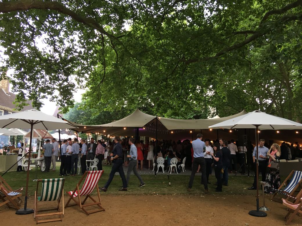 Vibrant outdoor event at The Museum of the Home with tent and string lights.