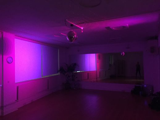 Versatile London rehearsal space with ambient purple lighting, ideal for events and presentations.