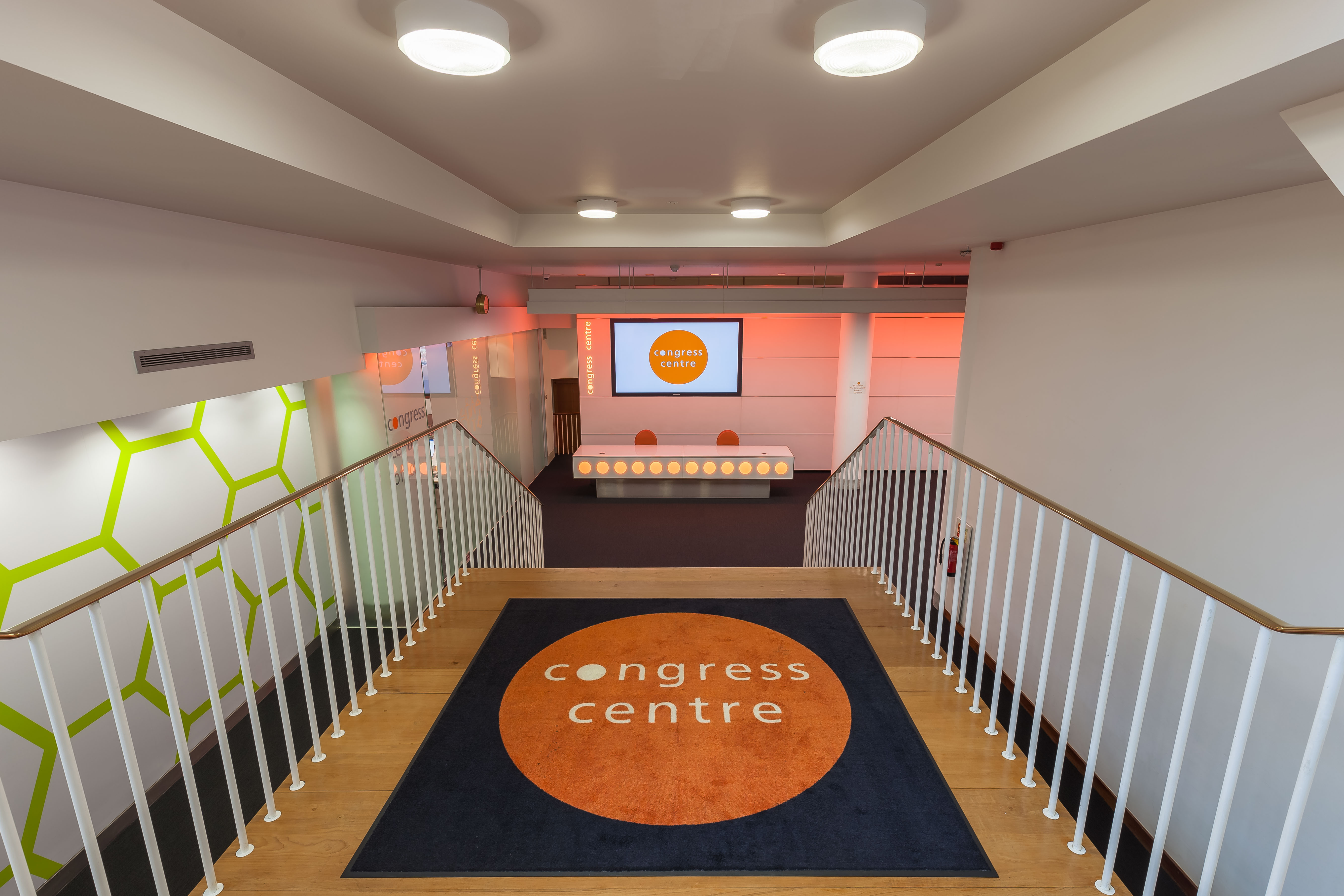 Modern congress center foyer with well-lit staircase, ideal for conferences and events.