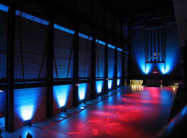 Turbine Hall at Tate Modern, spacious venue with dramatic blue and red lighting for events.