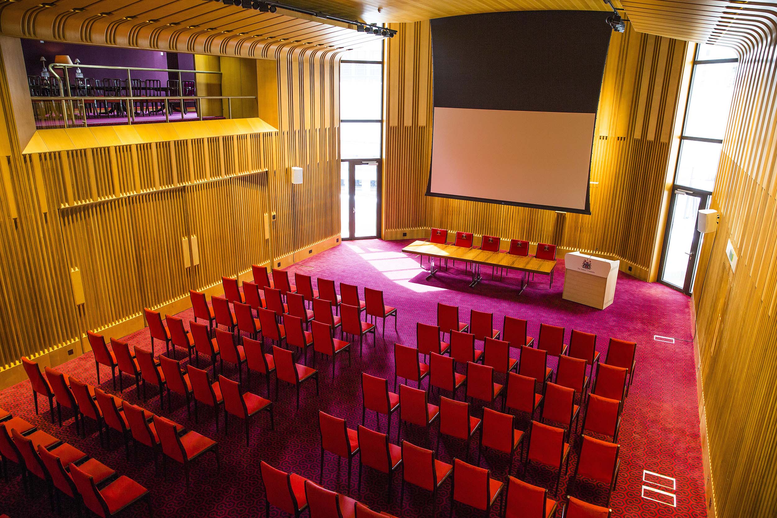 Main Hall at Salters' Hall with red chairs, perfect for presentations and workshops.