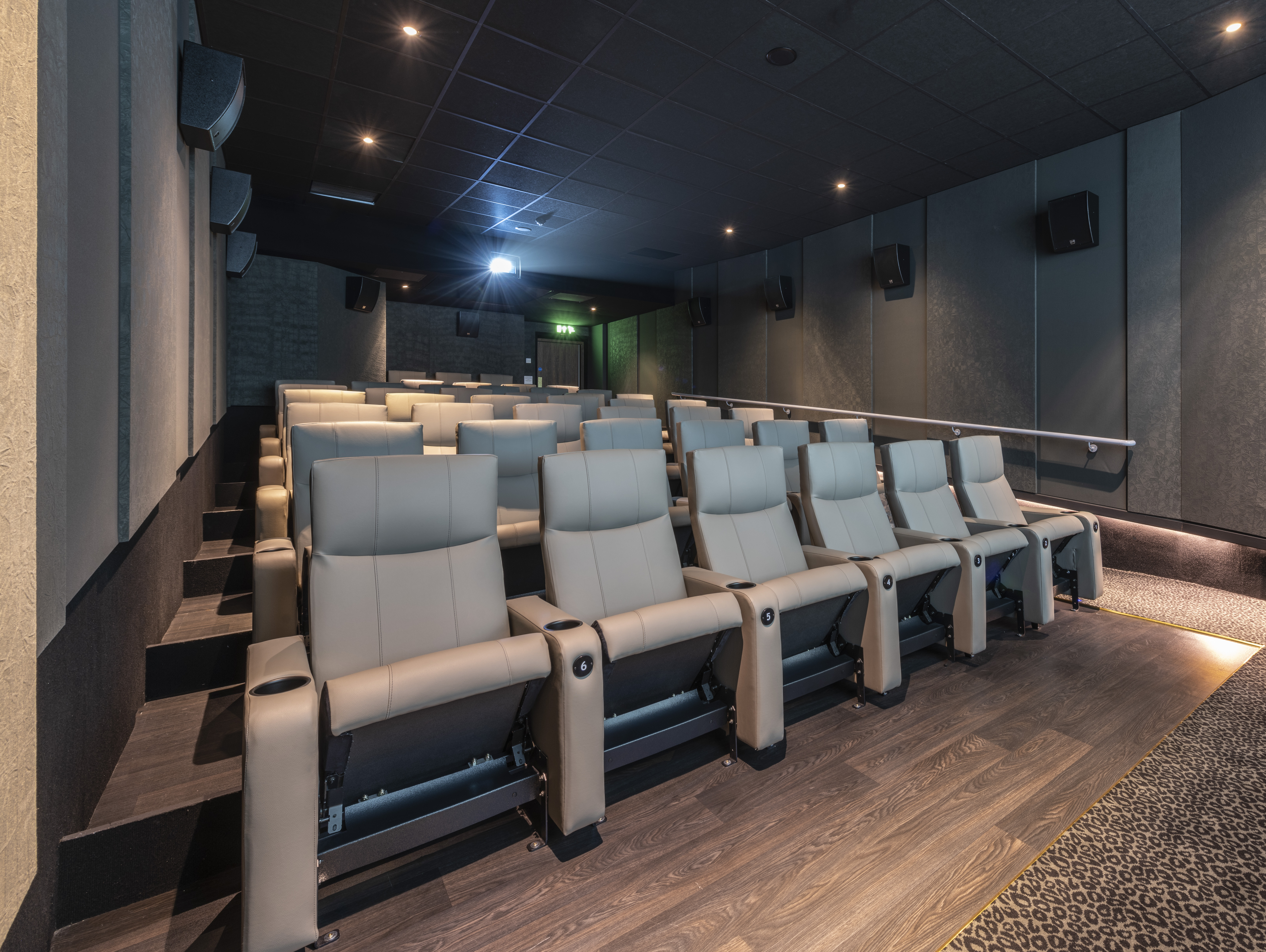 Modern theater with plush reclining seats for corporate events and film screenings.