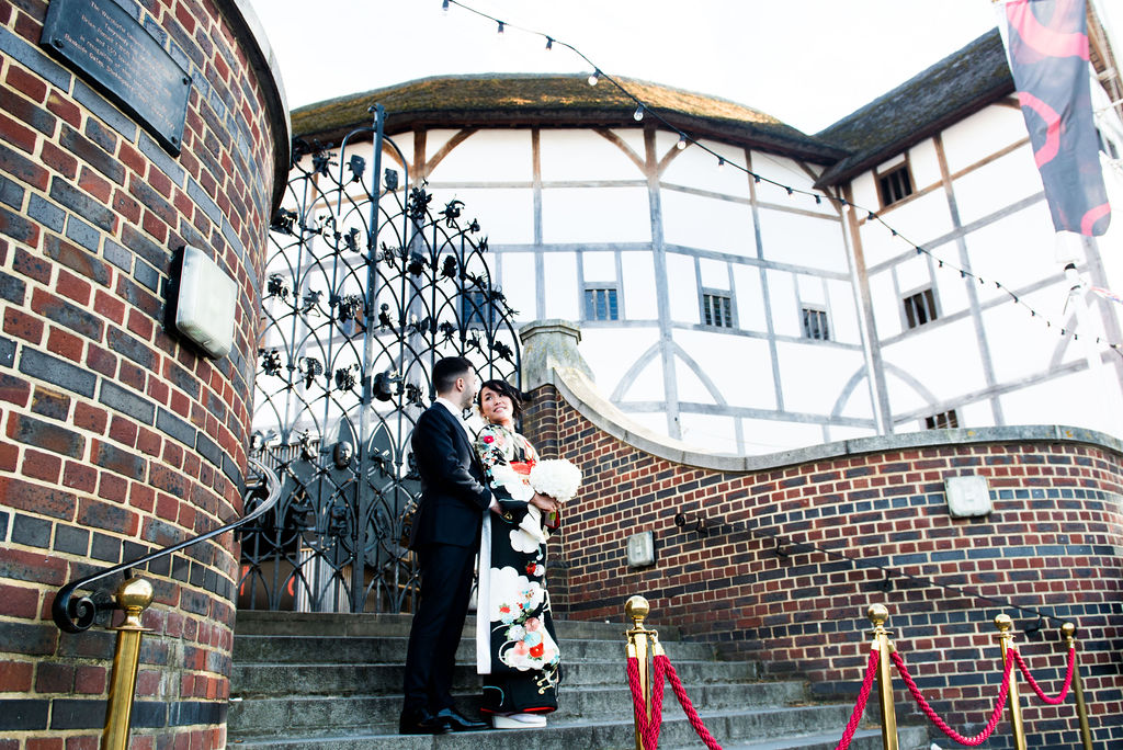 Couple at The Balcony Room entrance, elegant staircase for a wedding venue.