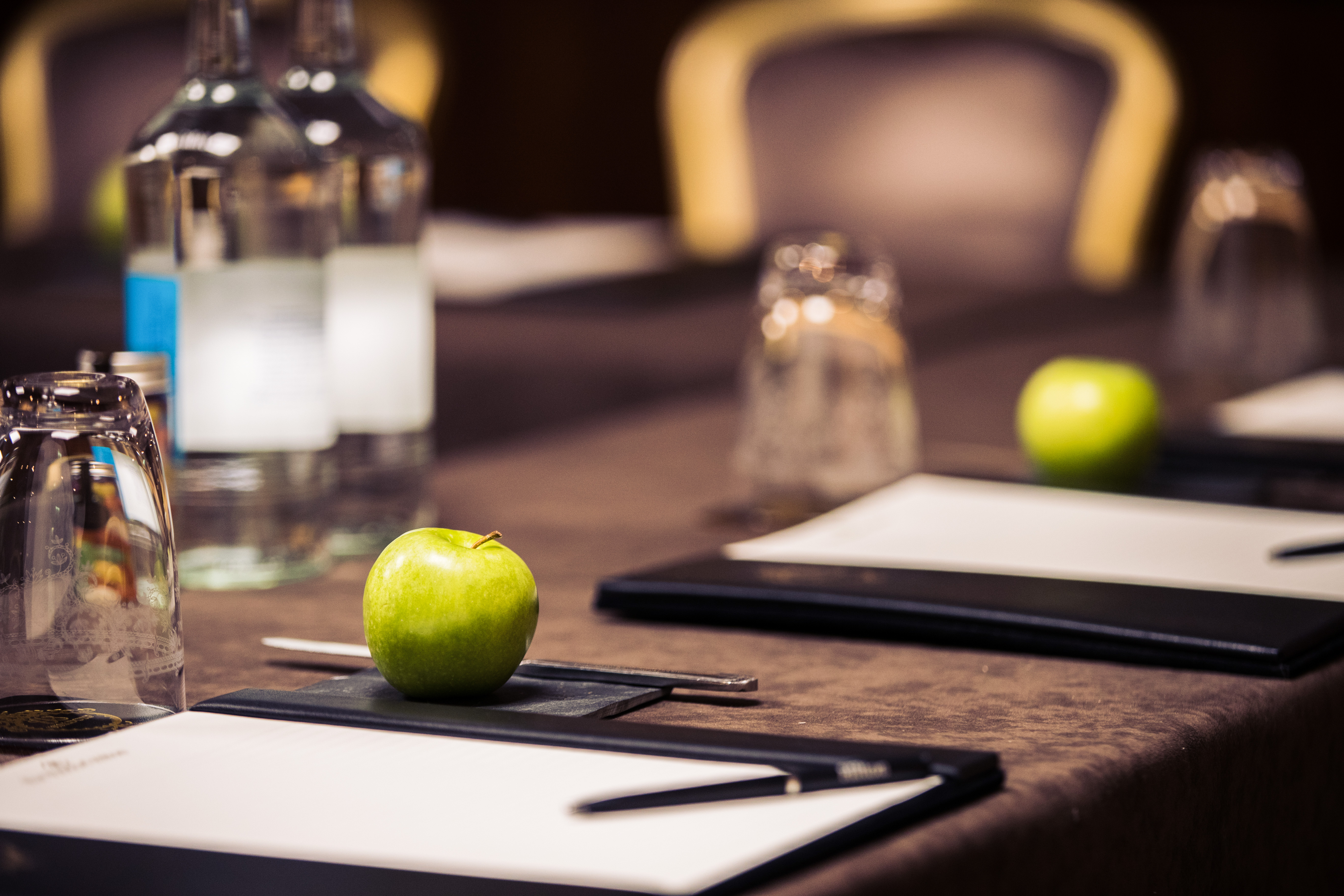 Aldwych Suite meeting setup at The Waldorf Hilton, London with polished table and notepads.