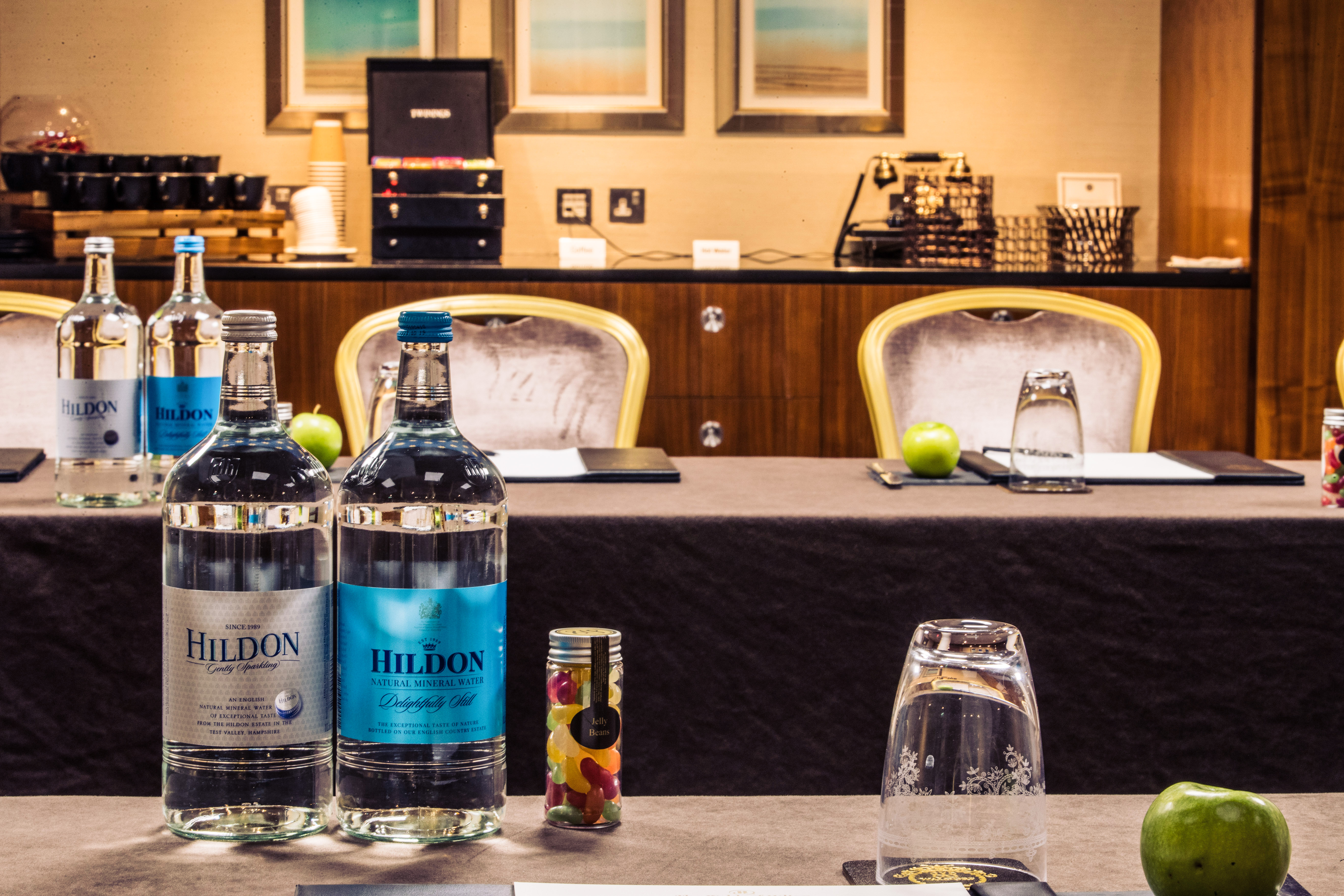 Mackenzie at The Waldorf Hilton, London: elegant meeting setup with water bottles and apples.