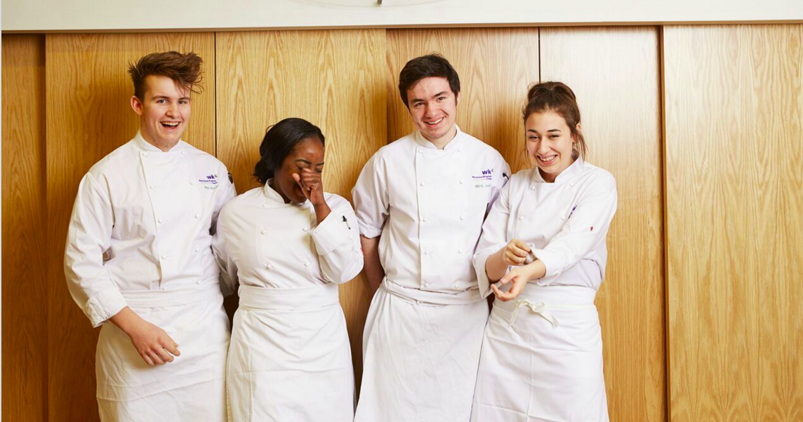 Chefs in professional attire showcasing teamwork at Culinary Academy event.