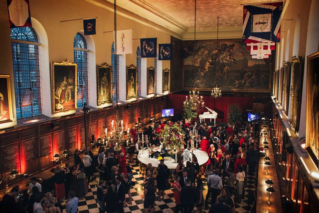 Great Hall at Royal Hospital Chelsea gala with elegant decor and chandeliers.
