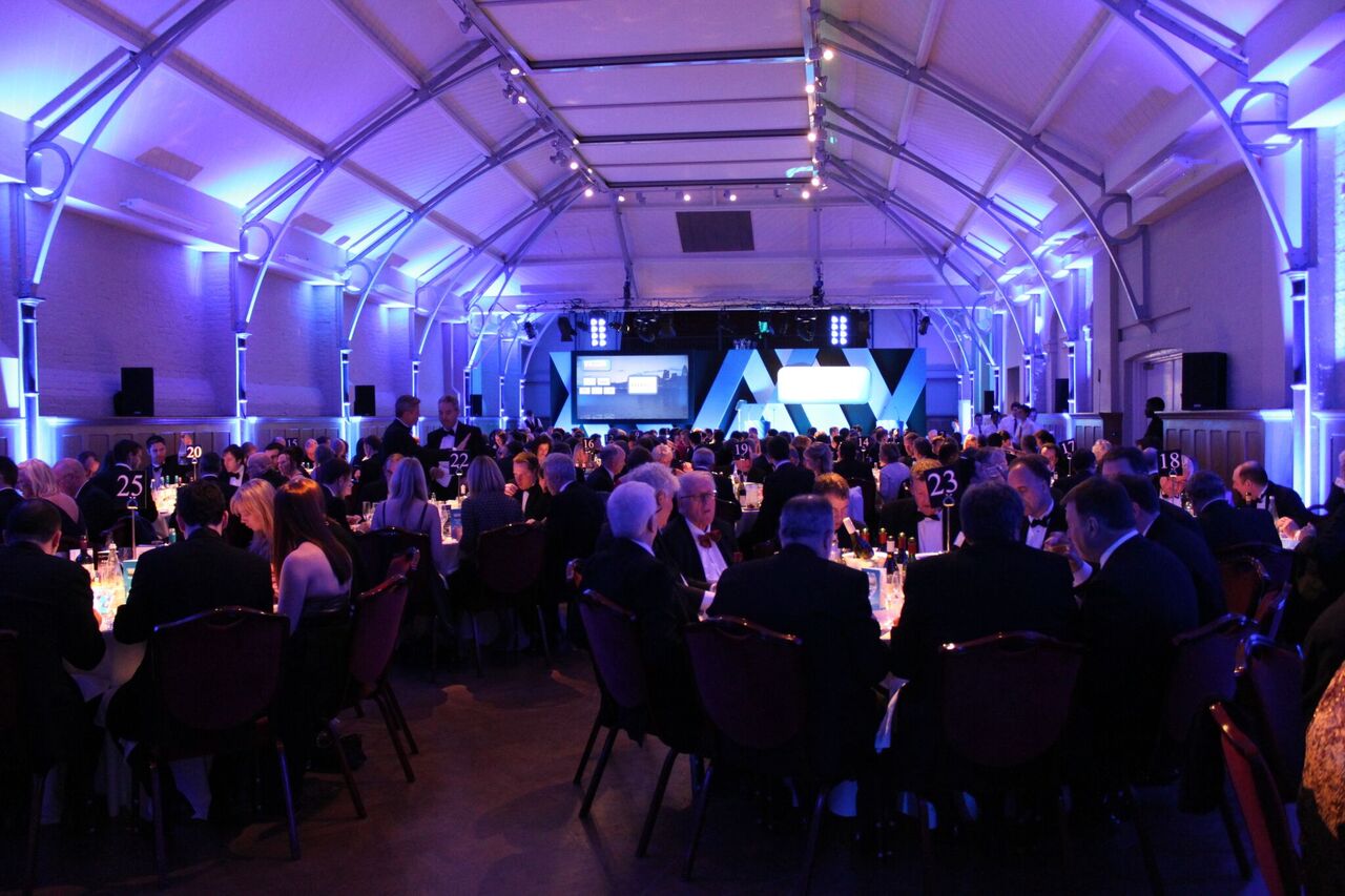 Gala event in Prince Consort Rooms, HAC with elegant table settings and blue lighting.