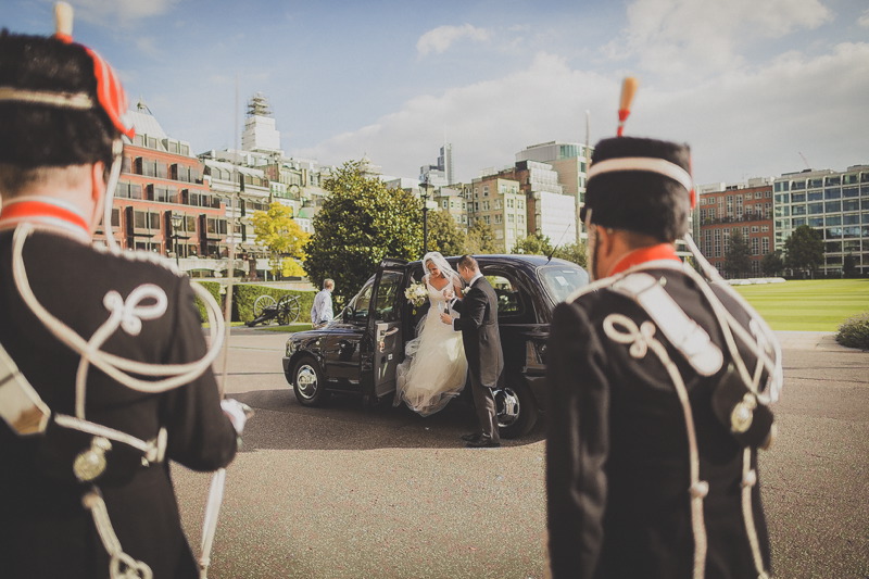 Wedding at Artillery Garden with bride, groom, and classic black taxi. Urban celebration.