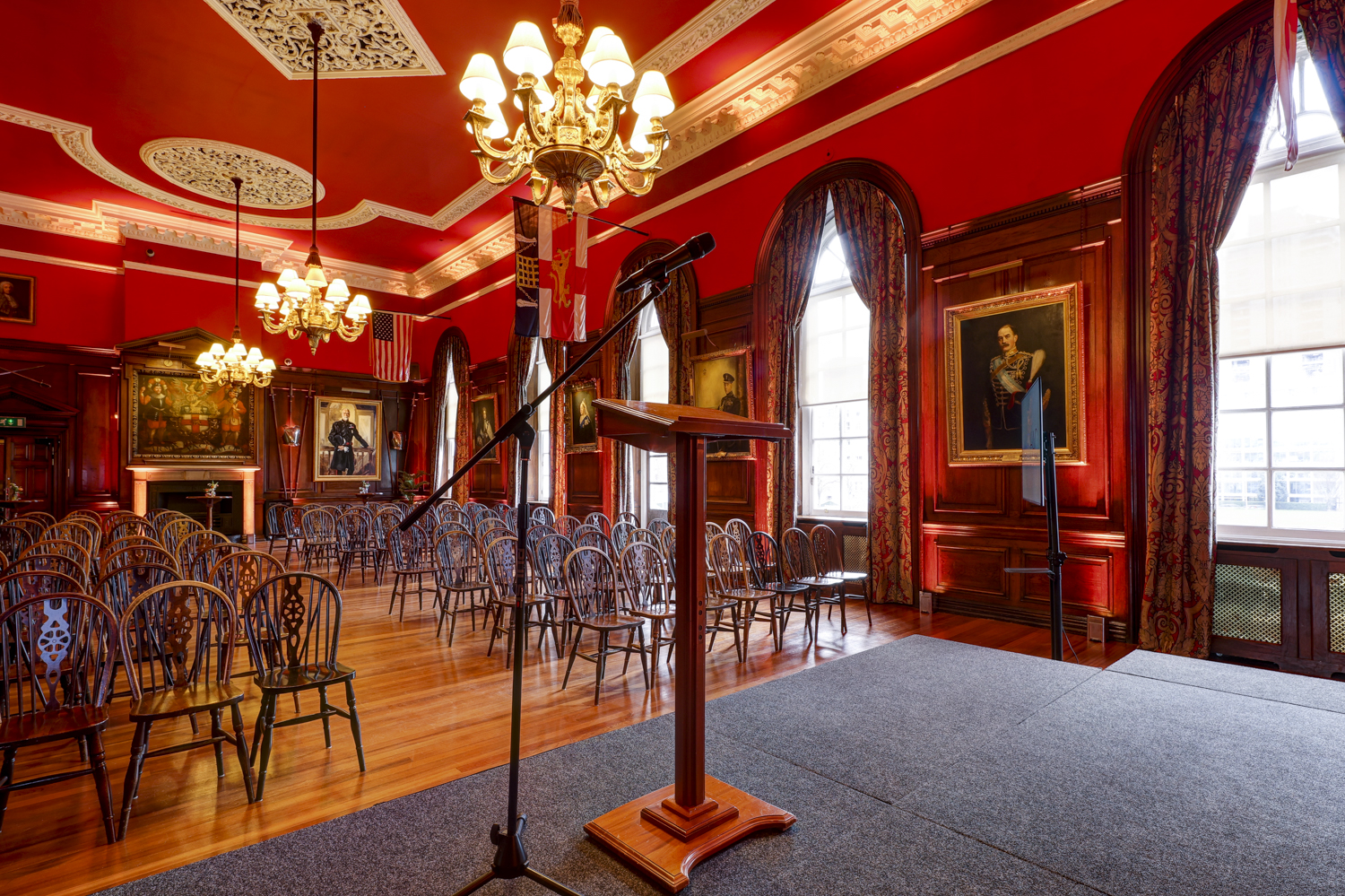 The Long Room at HAC with red walls, elegant chandeliers for events and meetings.