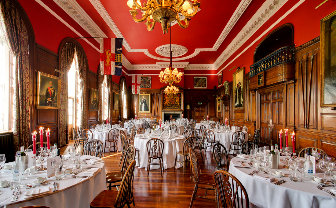 Elegant banquet hall with red walls, ideal for corporate events and galas.