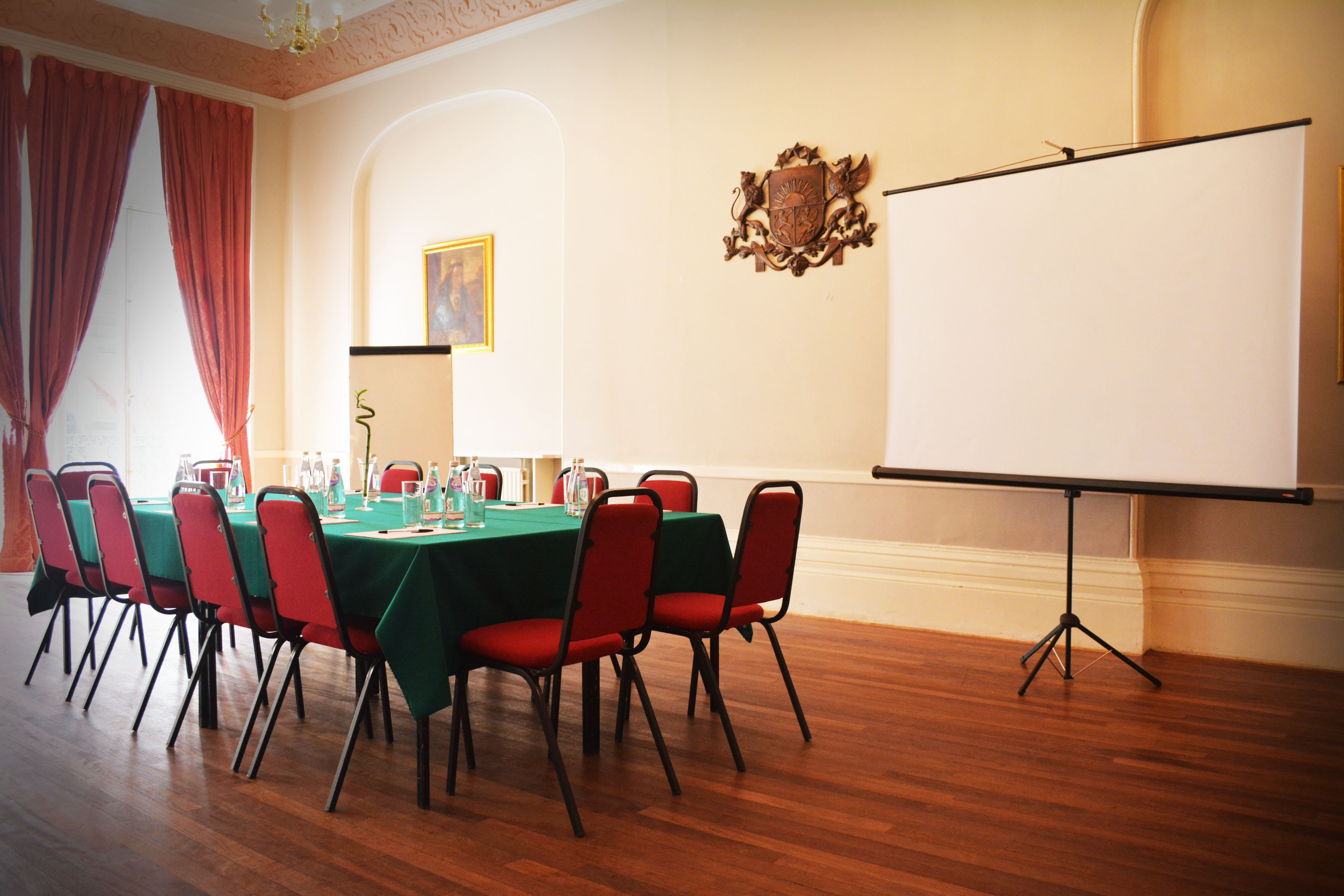 Queensborough Hall meeting room with red chairs, ideal for professional gatherings and presentations.