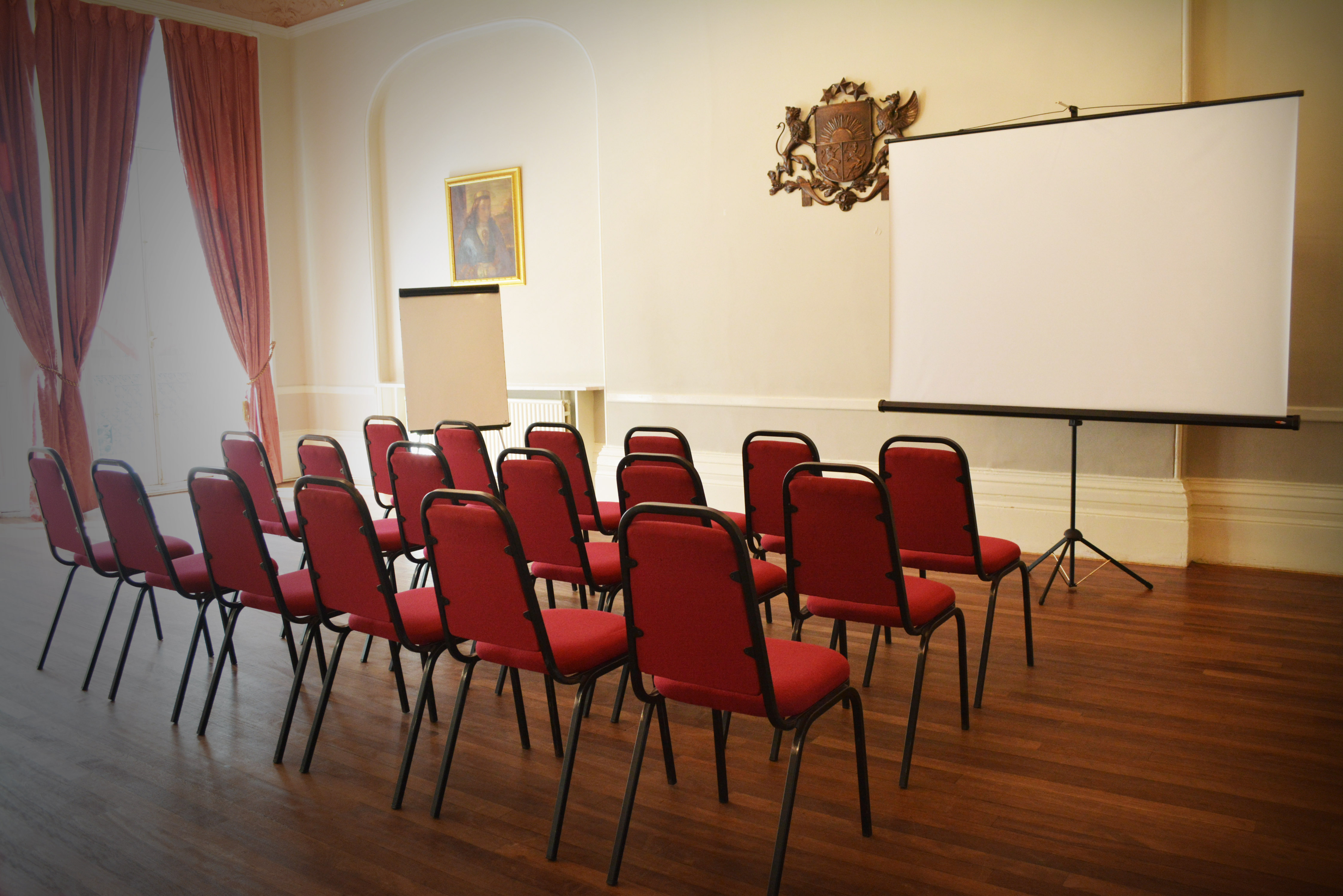 Queensborough Hall meeting space with red chairs, ideal for workshops and presentations.