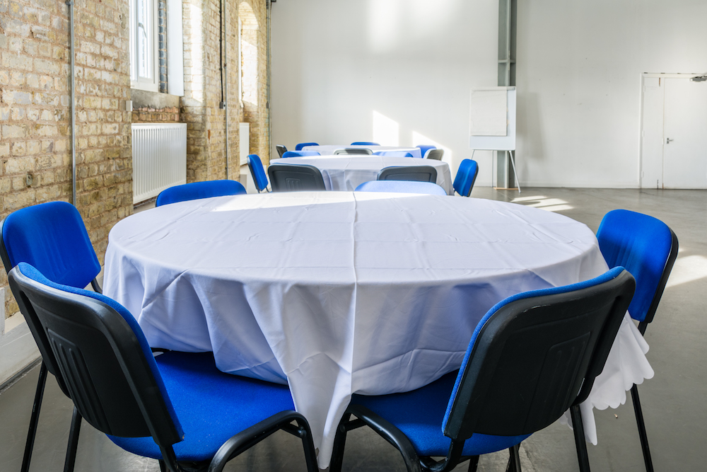 Fishing Smack Studio with round tables and blue chairs, perfect for meetings and workshops.