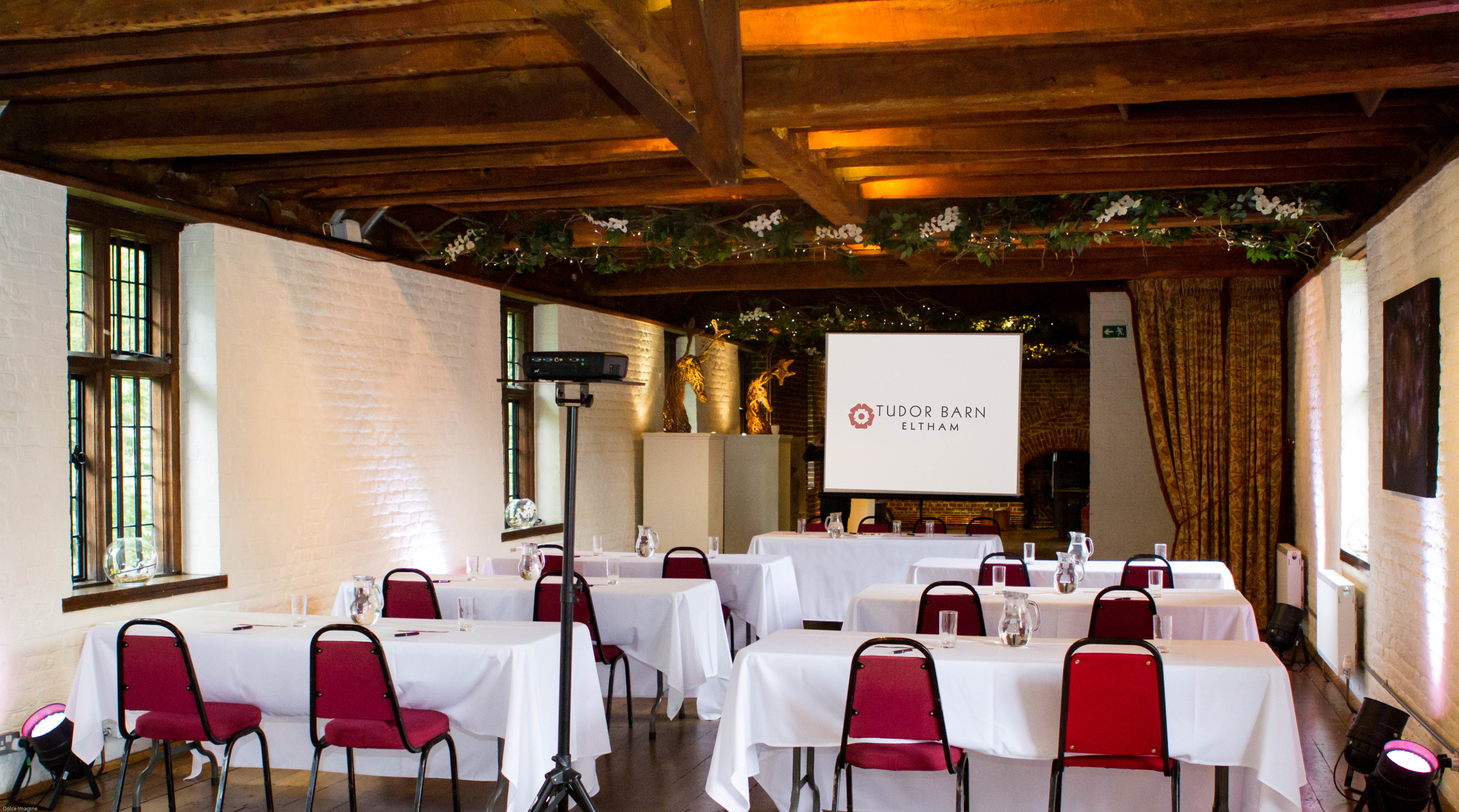 Tudor Barn Eltham meeting space with red chairs, perfect for corporate events and workshops.