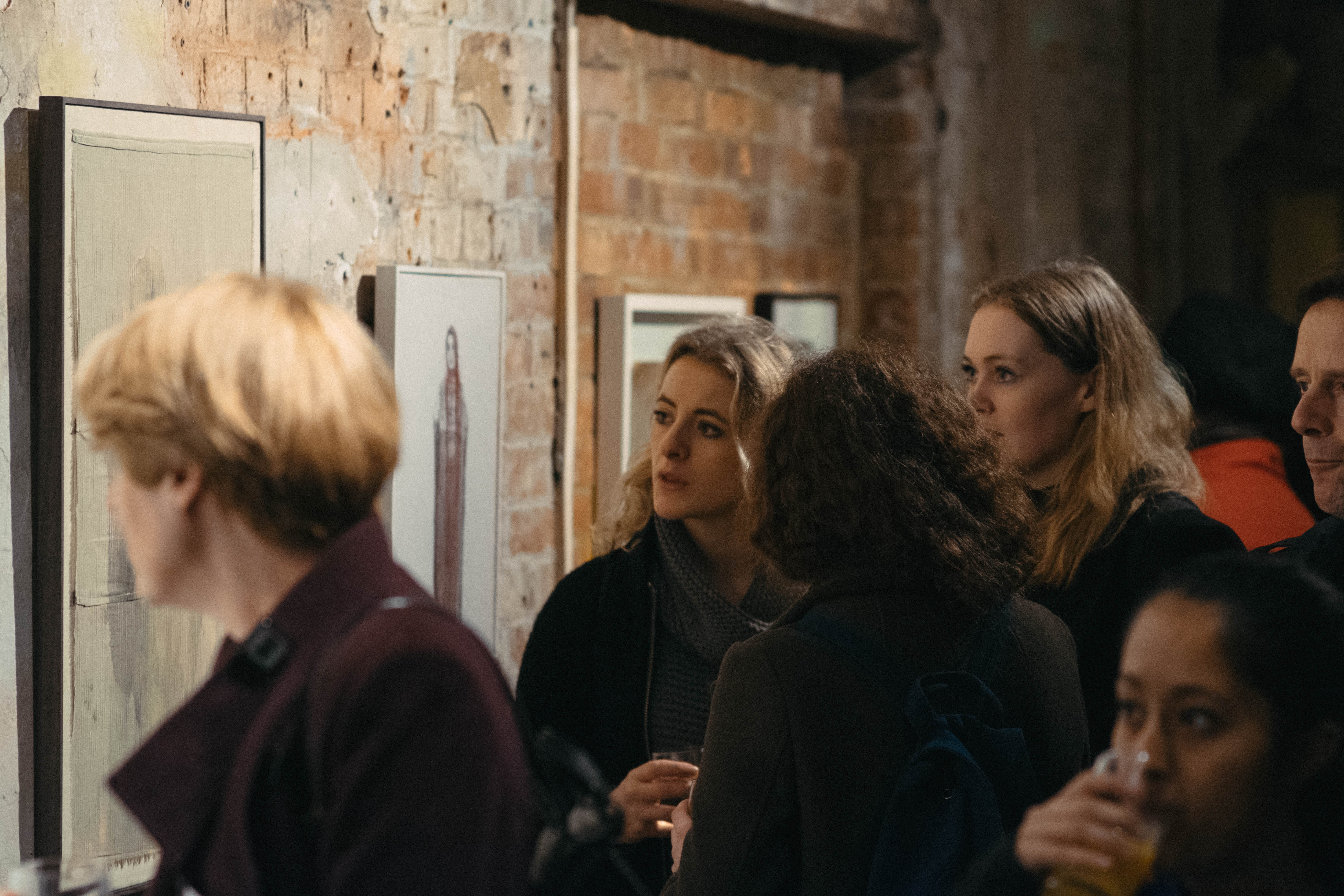 Engaged attendees at OXO Tower art exhibition, fostering networking and immersive experiences.