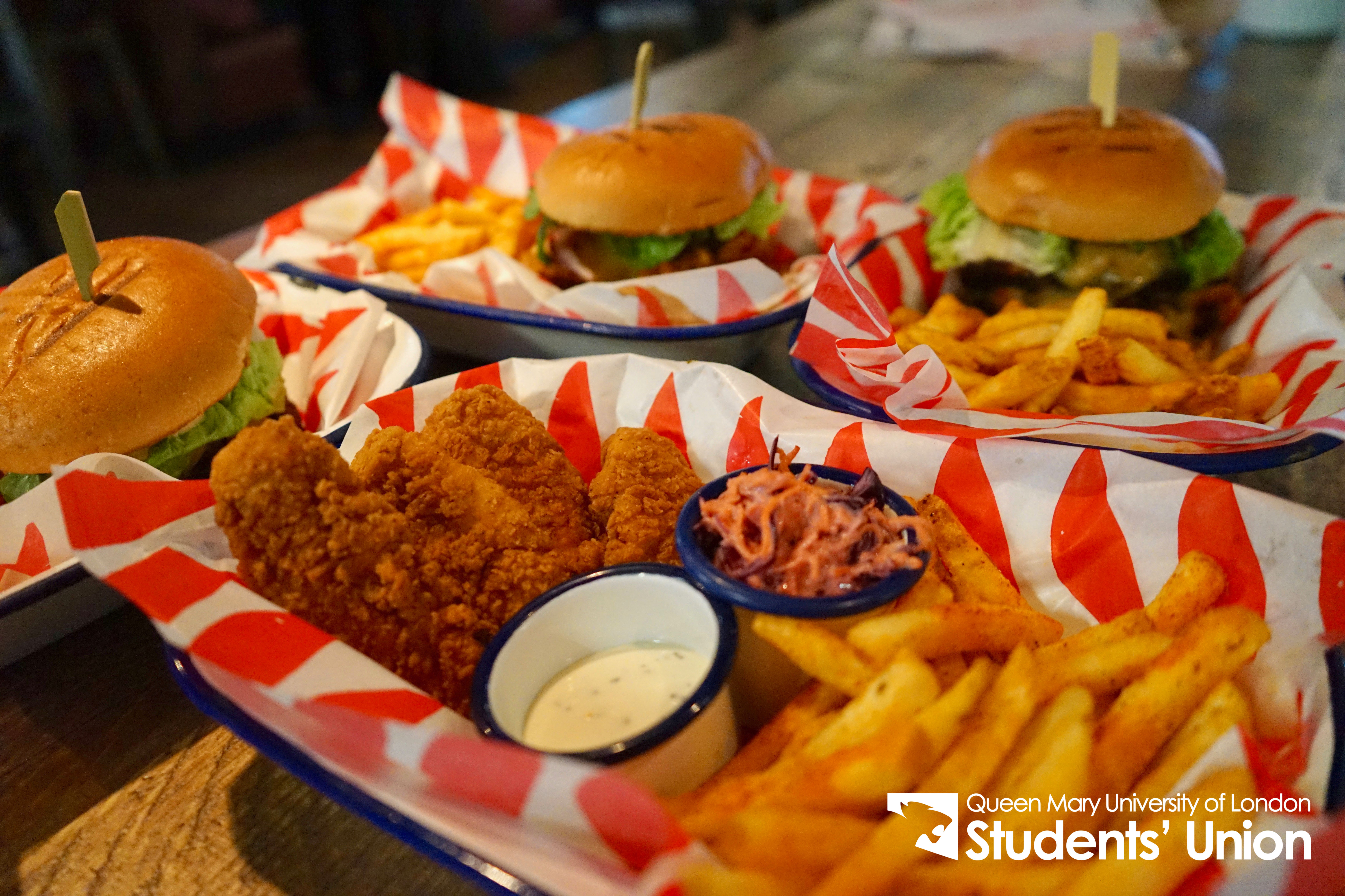 Vibrant catering setup with burgers and fries at Drapers Bar & Kitchen for events.