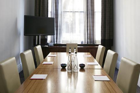 Private dining room with long table and natural light, perfect for meetings and workshops.